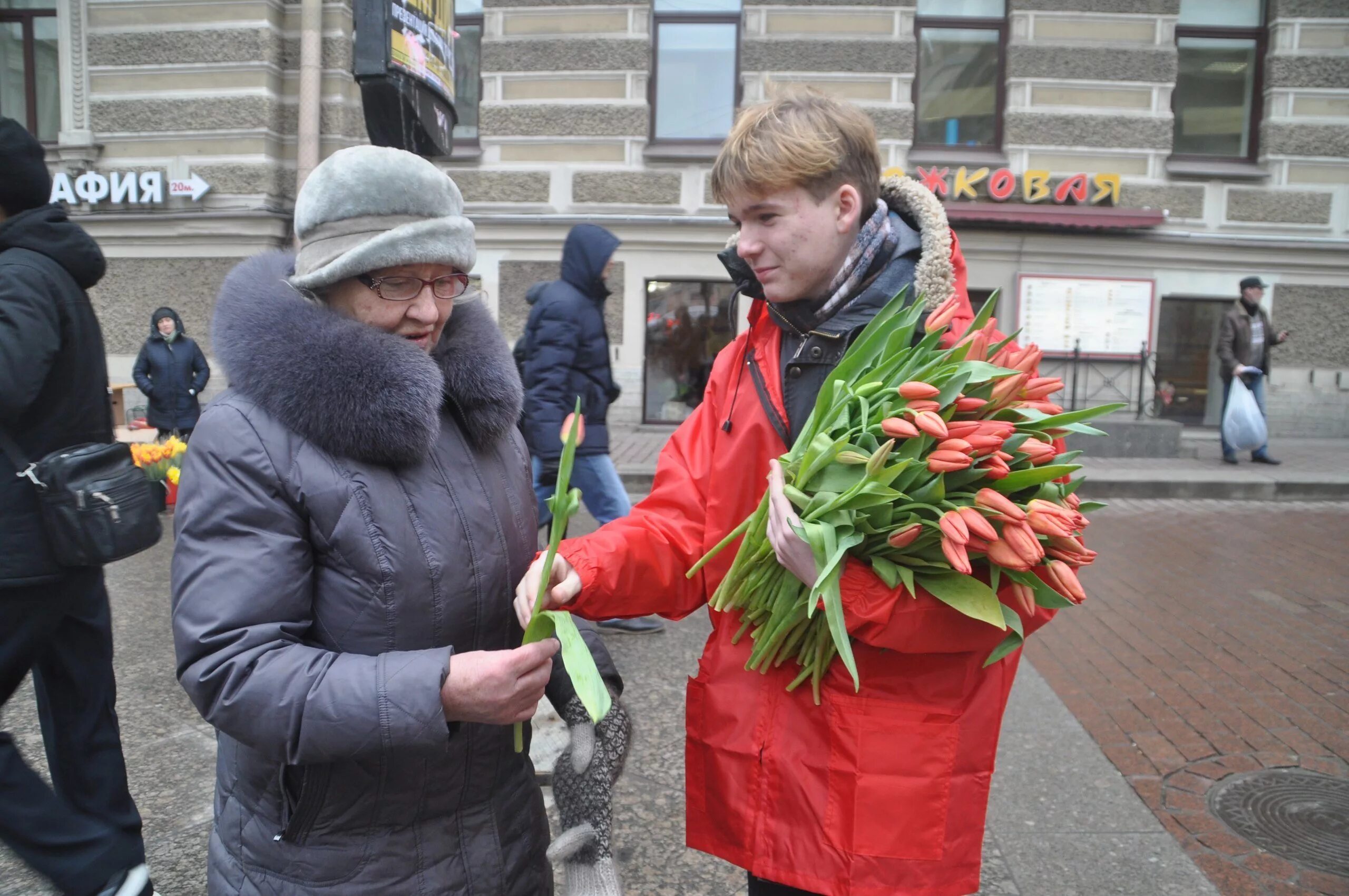 Цвета международного женского дня. Дарят цветы на улице.