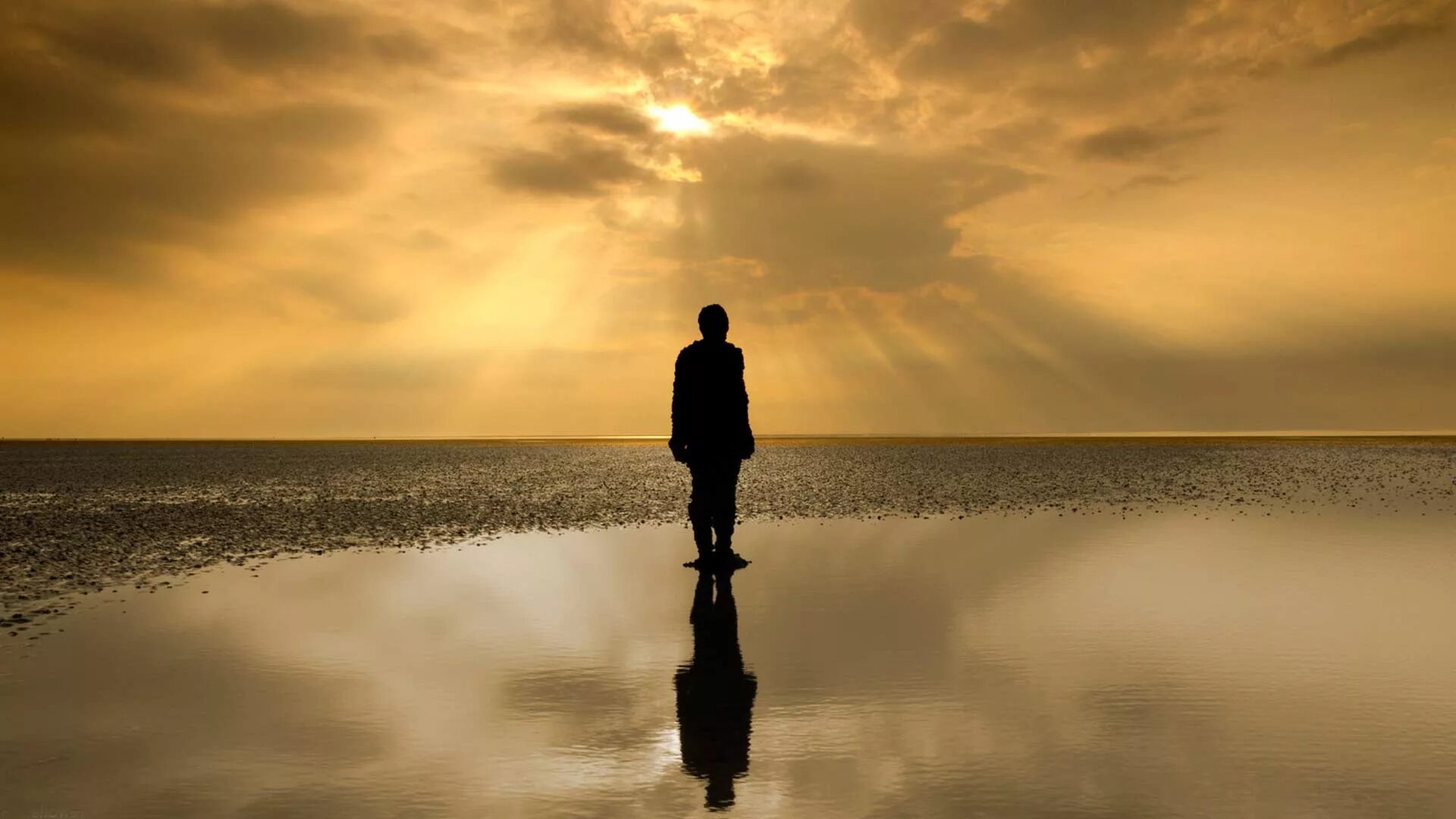 Идущий вдали. Одинокий человек. Одинокая фигура на берегу моря. Одинокий мужчина на берегу. Силуэт уходящего мужчины.