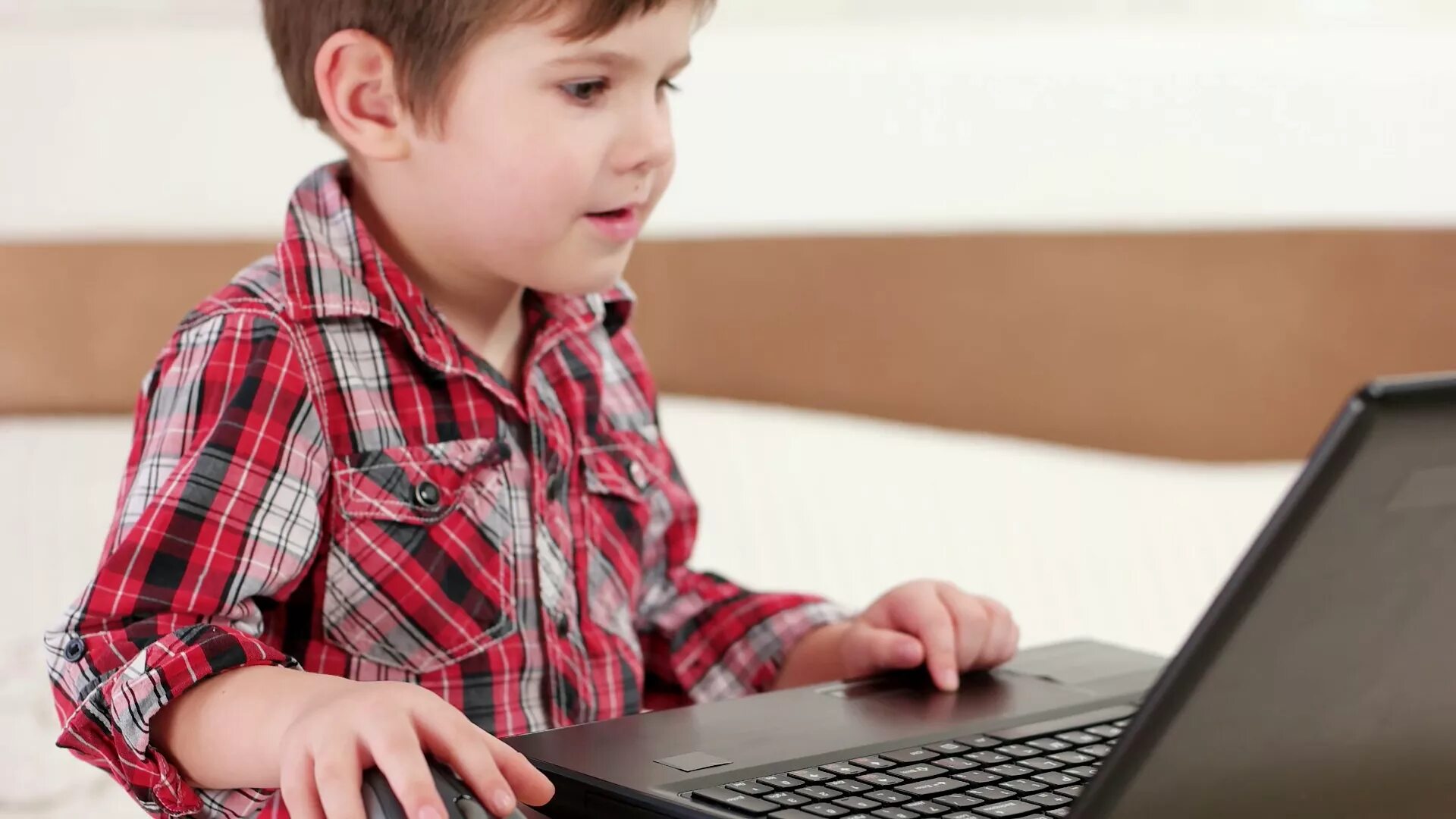 The boy is playing the computer
