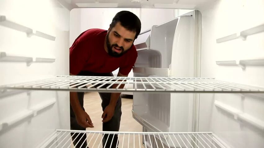 Пустой холодильник. В холодильнике пусто. Заглядывает в пустой холодильник. Опустевший холодильник.