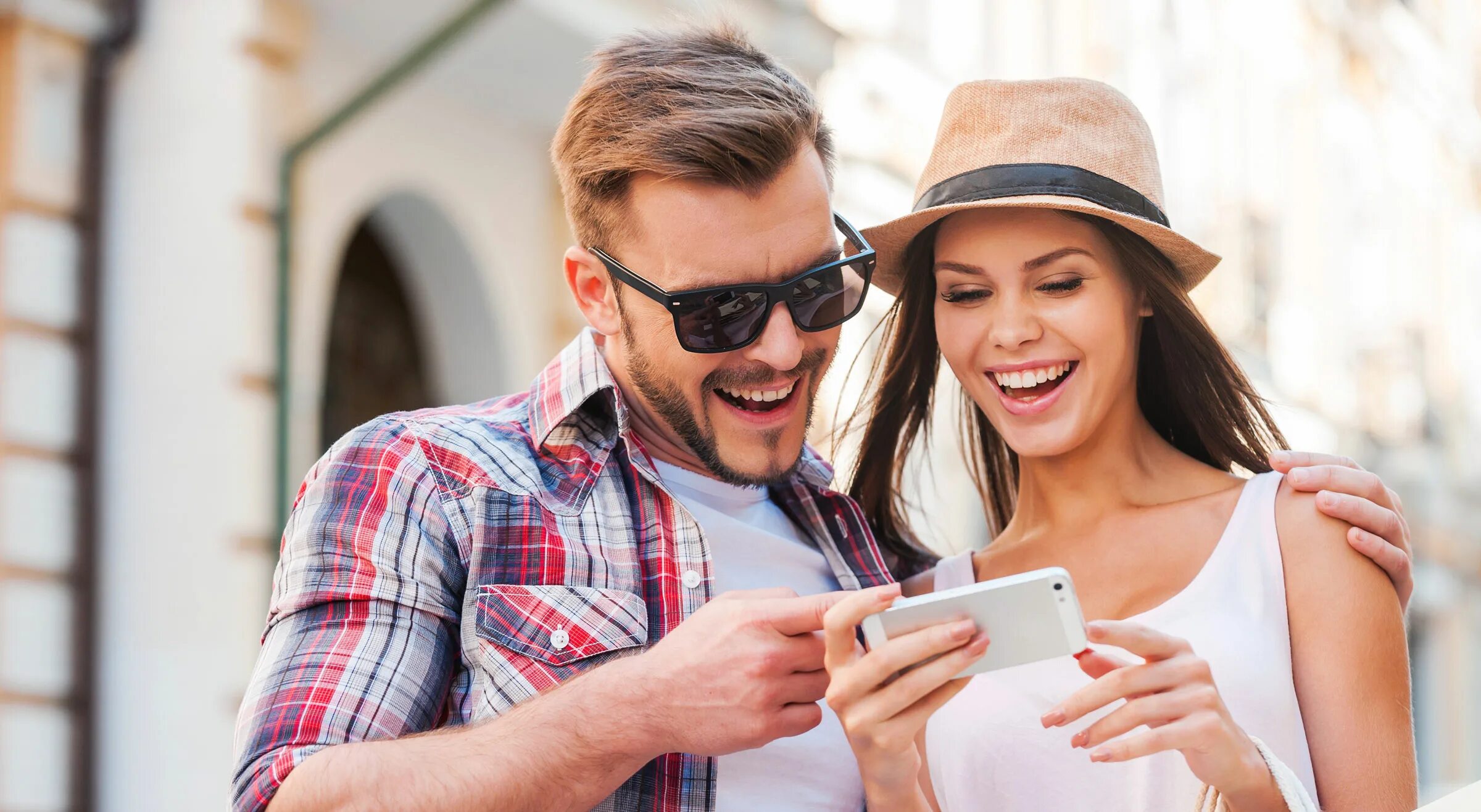 Use your friends. Радостные молодые люди и смартфон. Пара со смартфонами. Счастливая пара с телефоном. Молодые люди со смартфонами.