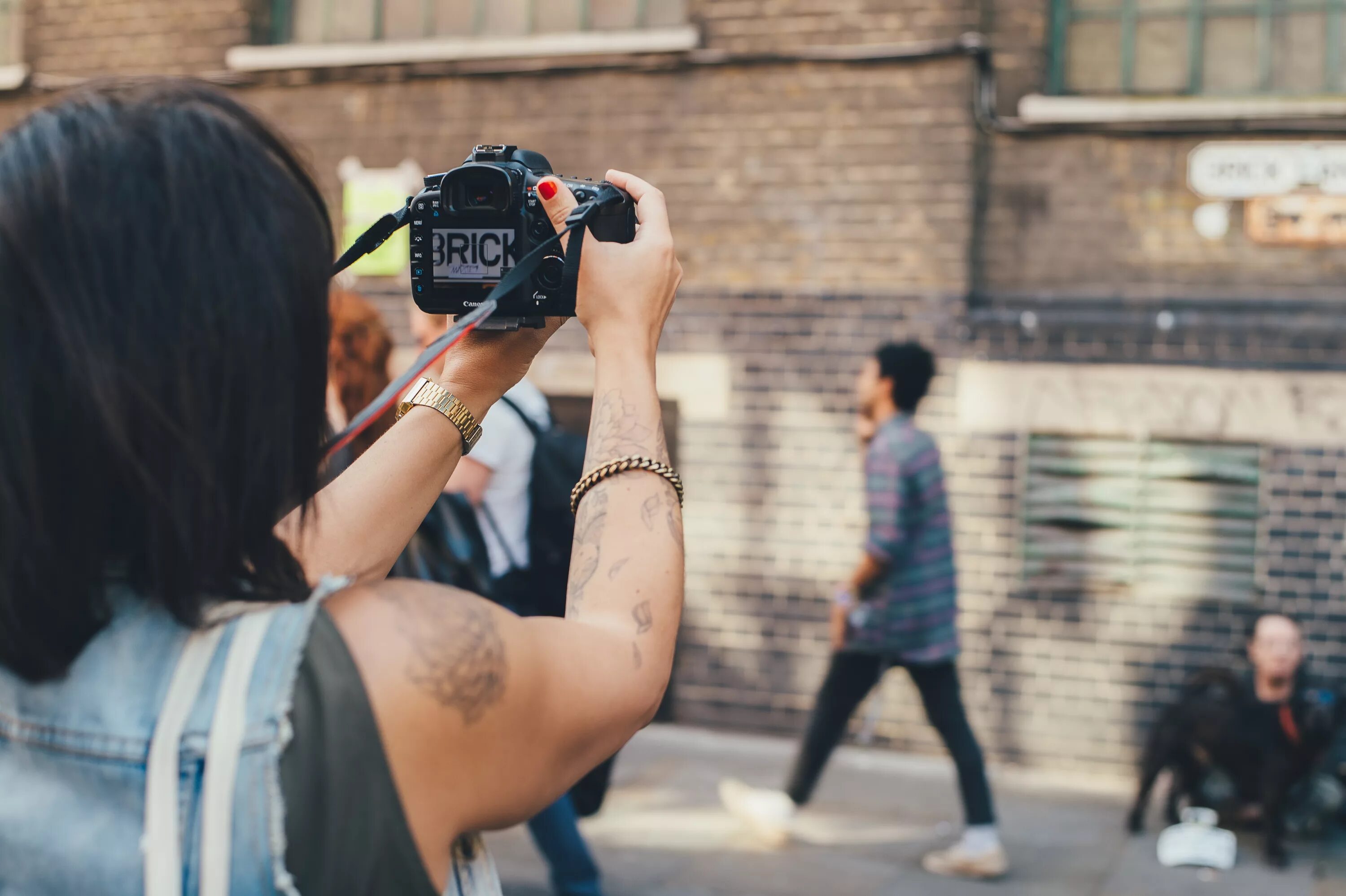 Как одновременно снимать видео и слушать музыку. Девушка фотографирует. Девушка фотограф. Фотограф фотографирует на улице. Фотосессия для фотографа.