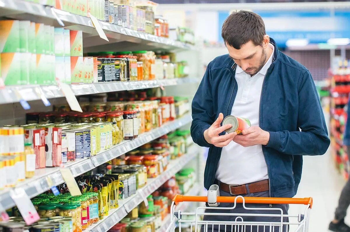 Выберите продукт. Мужчина в супермаркете. выбор продуктов. покупатель продуктов. потребители пищевой продукции.