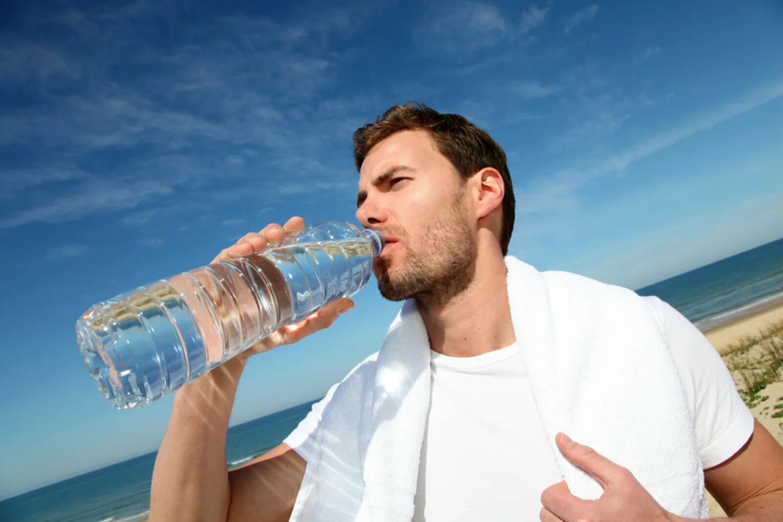Человек пьет из бутылки. Человек с бутылкой воды. Человек пьет воду. Мужчина пьет воду. Парень пьет воду.