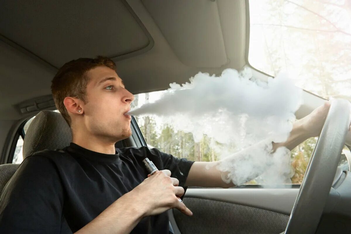 Курит в машине. Парень с сигаретой в машине. Курение за рулем. Парень курит в машине.