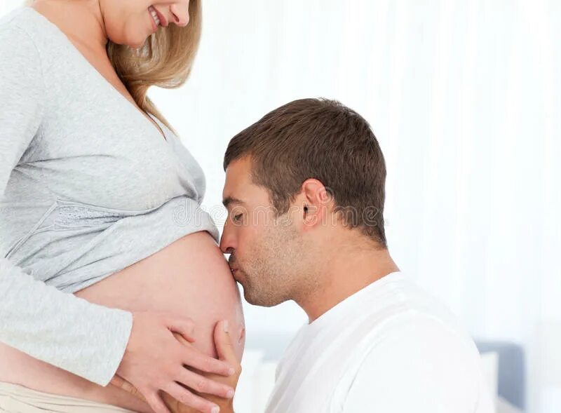 Планирование беременности фото. Будущие родители. Целует живот. Парень целует живот беременной девушке.