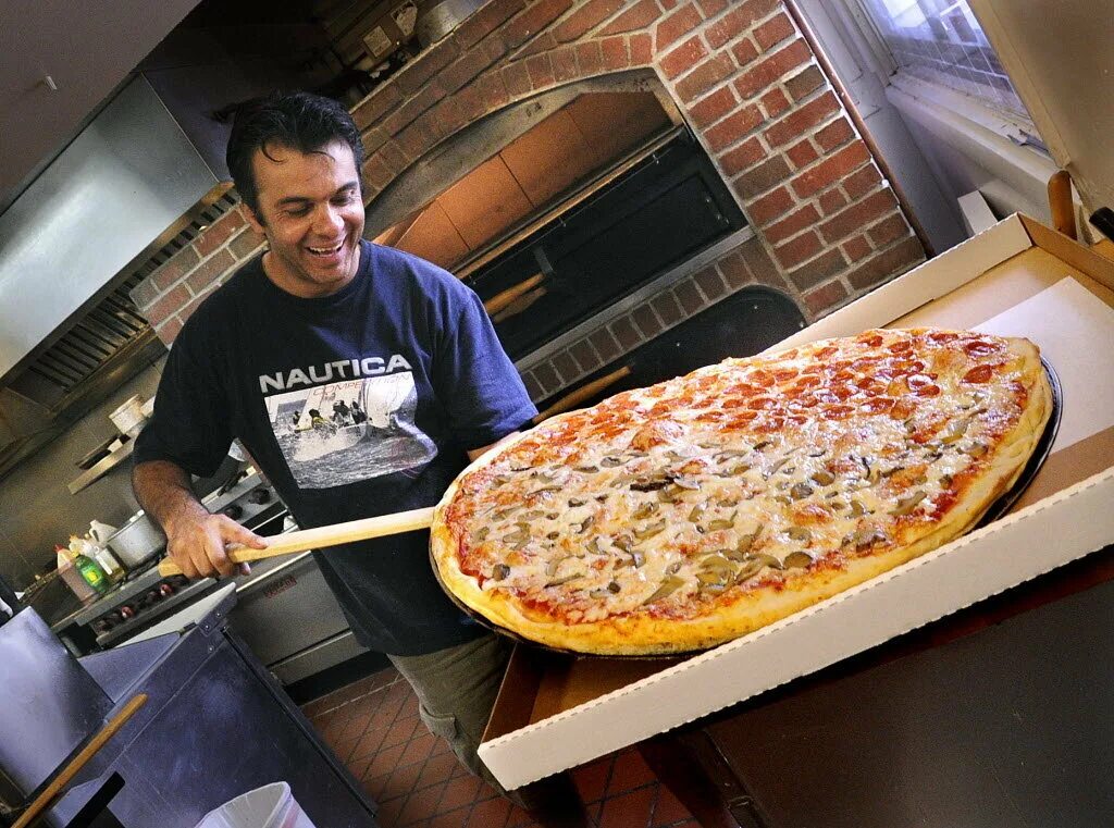 Пиццерия возле. Огромная пицца. Американская пиццерия. Пицца в пиццерии. Огромная вкусная пицца.