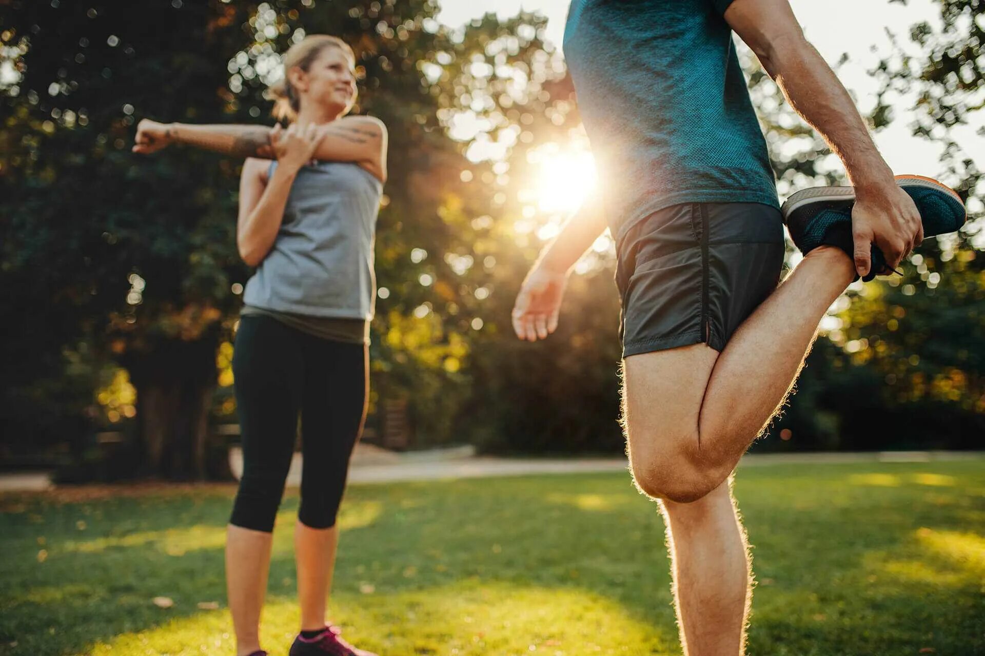 Спортивные люди. Занятие спортом на улице. Разминка. Зарядка перед пробежкой.