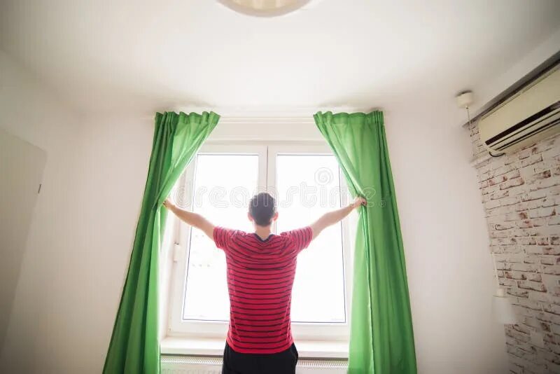 The curtains are in on the. The man opening the curtain. человек открывает штору с одной стороны. open curtain. open curtains morning.