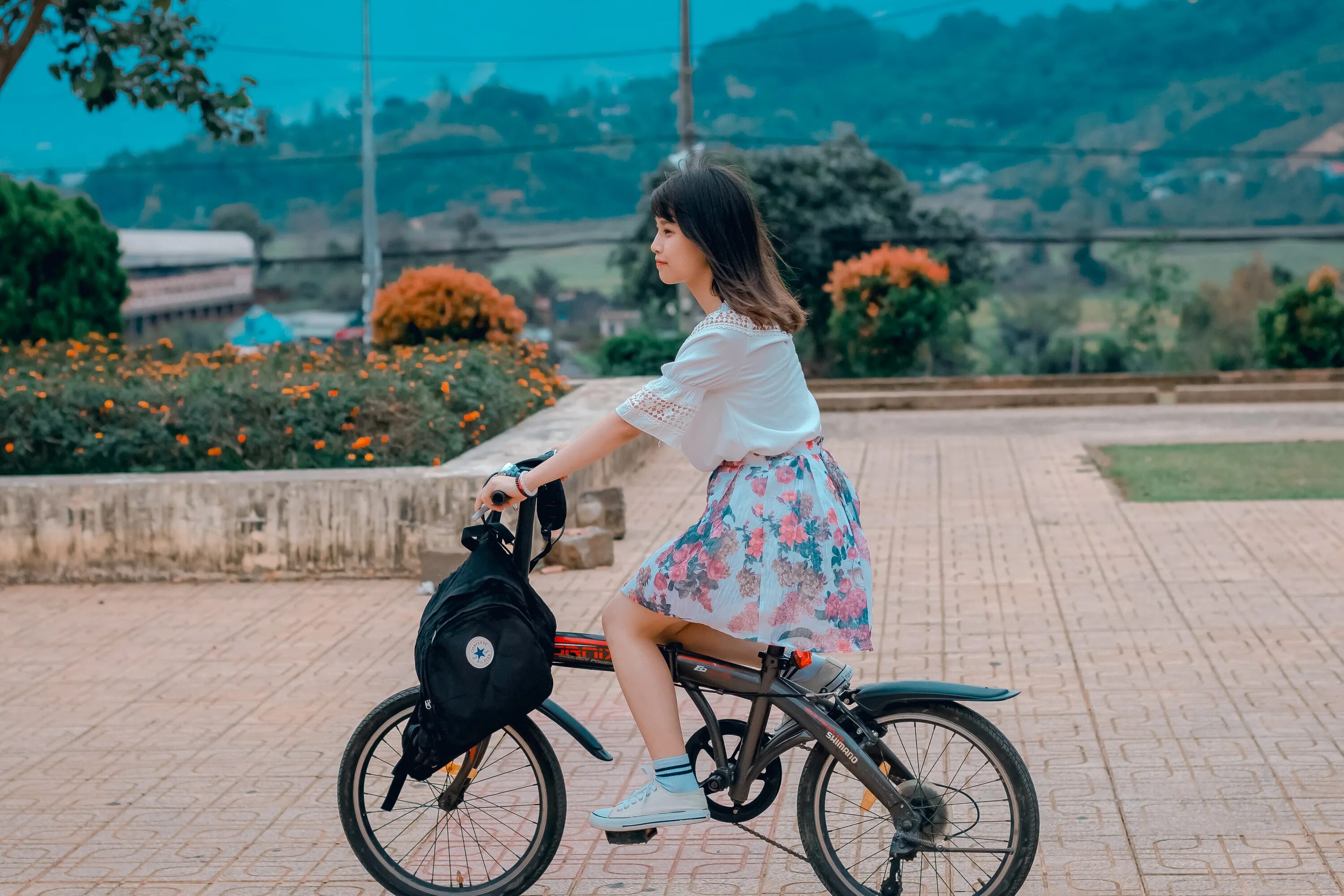 Девушка едет на велосипеде. Девочка катается на велосипеде. Маленькая девочка едет на велосипеде. Девушка садится на велосипед.