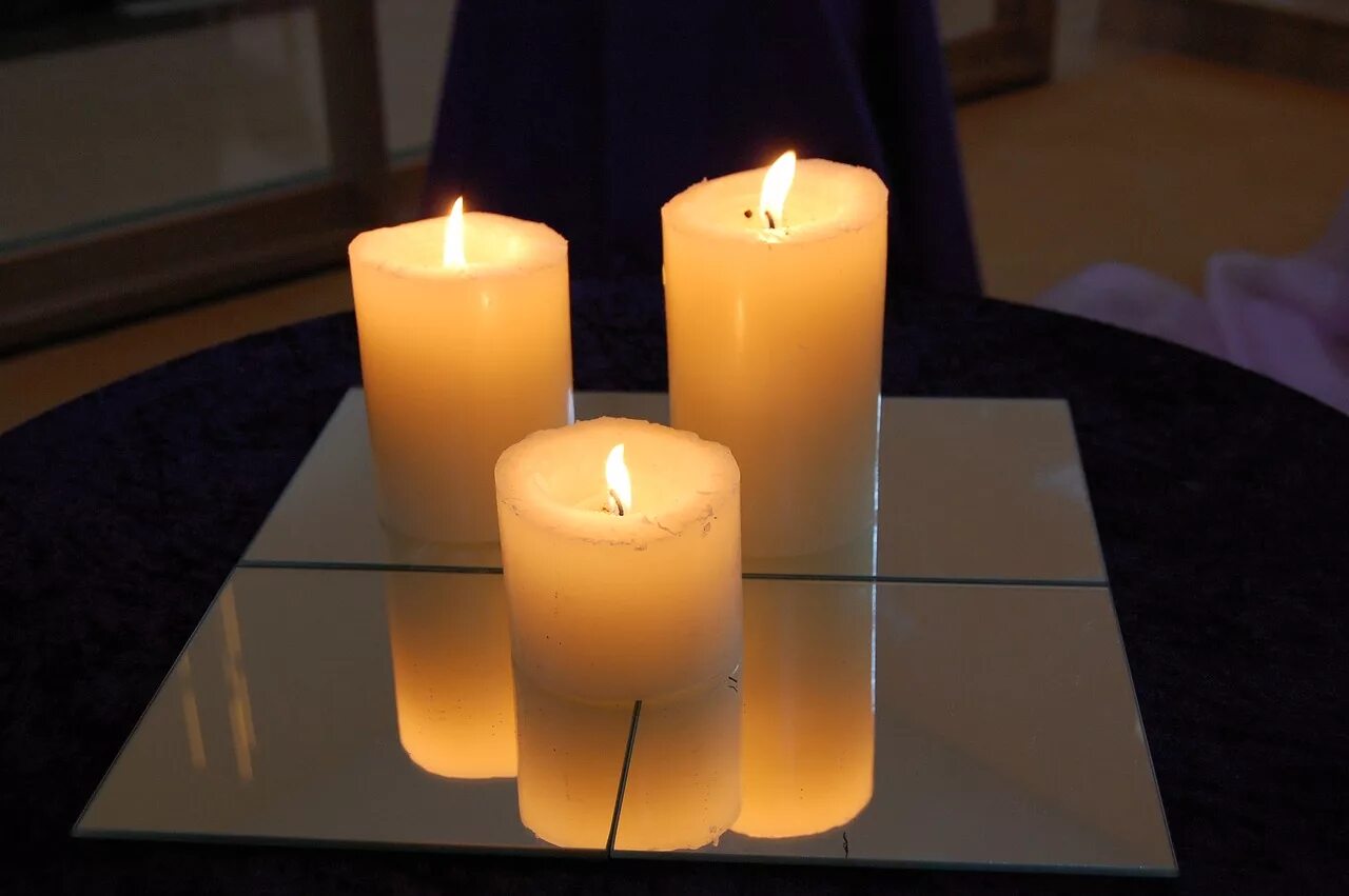 Свеча отражается в зеркале. Свечи. Три свечи. Зажженная свеча. Свеча на столе.