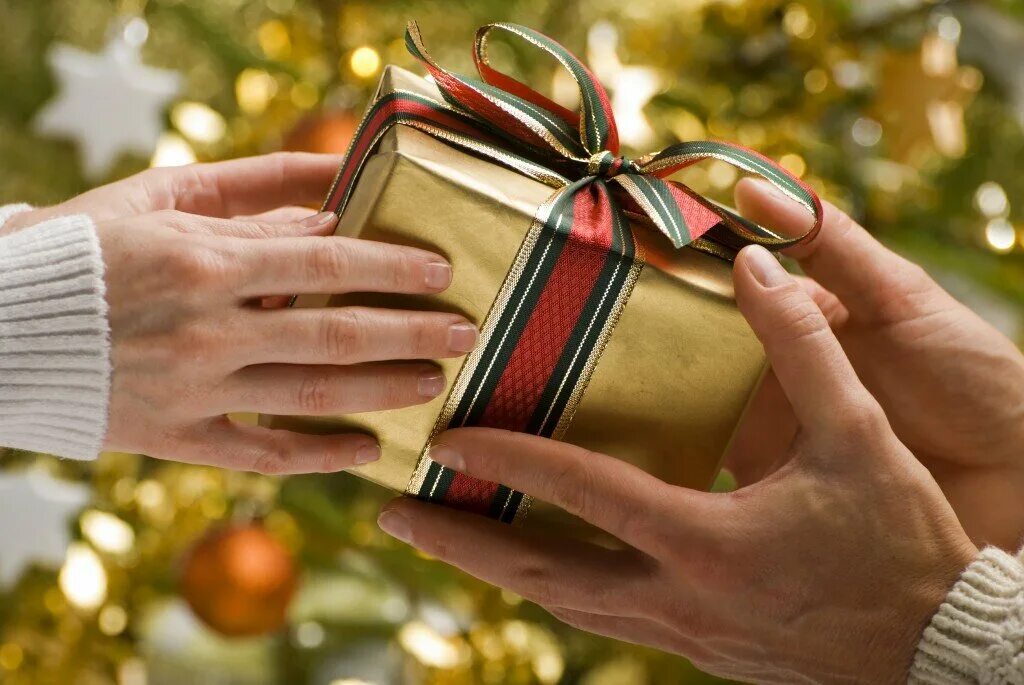 Новогодние подарки. Подарок в руках. Рождественские подарки. Дарение подарков.