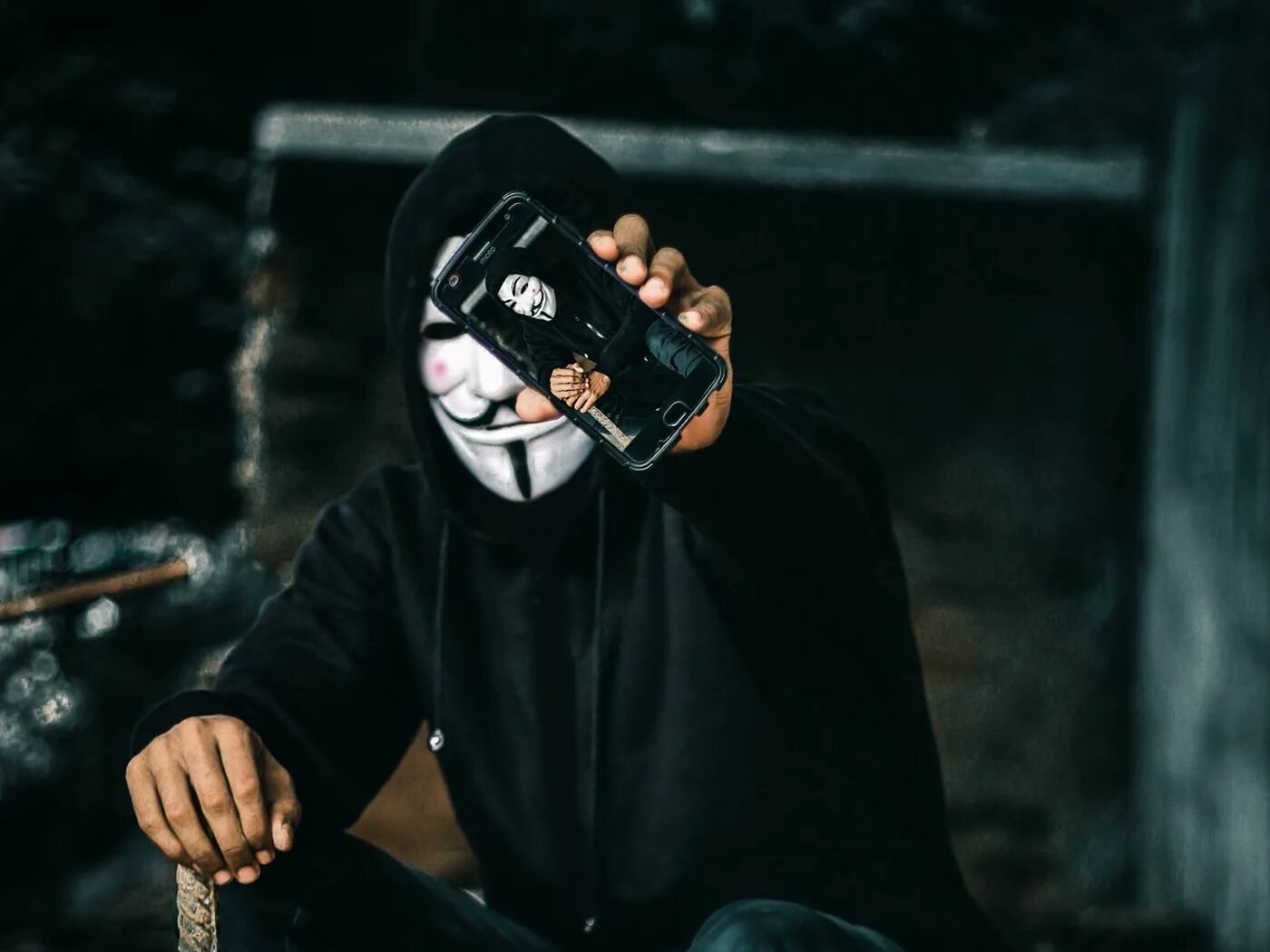 Кого рассекретили в маске 5. Анонимус с телефоном. Человек в маске с телефоном. Маска хакера. Обои для пацанов.