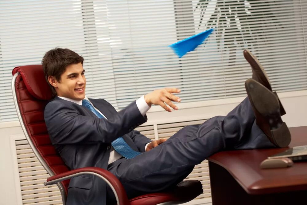 Время отдыха на работе. Бизнесмен в кресле. Кресло начальника. Сидит в офисе. Мужчина сидит в офисе.