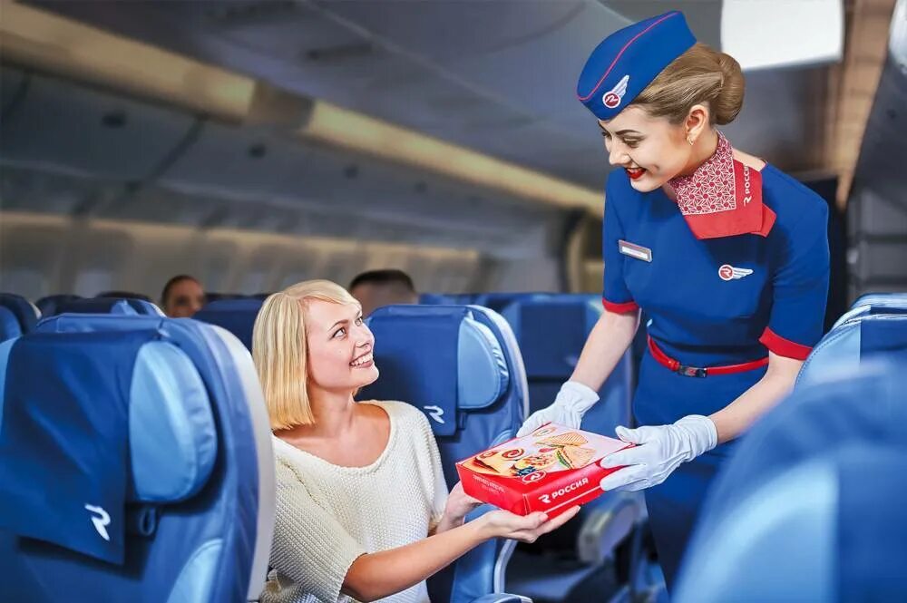 Новые правила аэрофлота. Авиакомпания Россия. Стюардесса с едой. Стюардесса на борту. Стюардесса с едой в самолете.