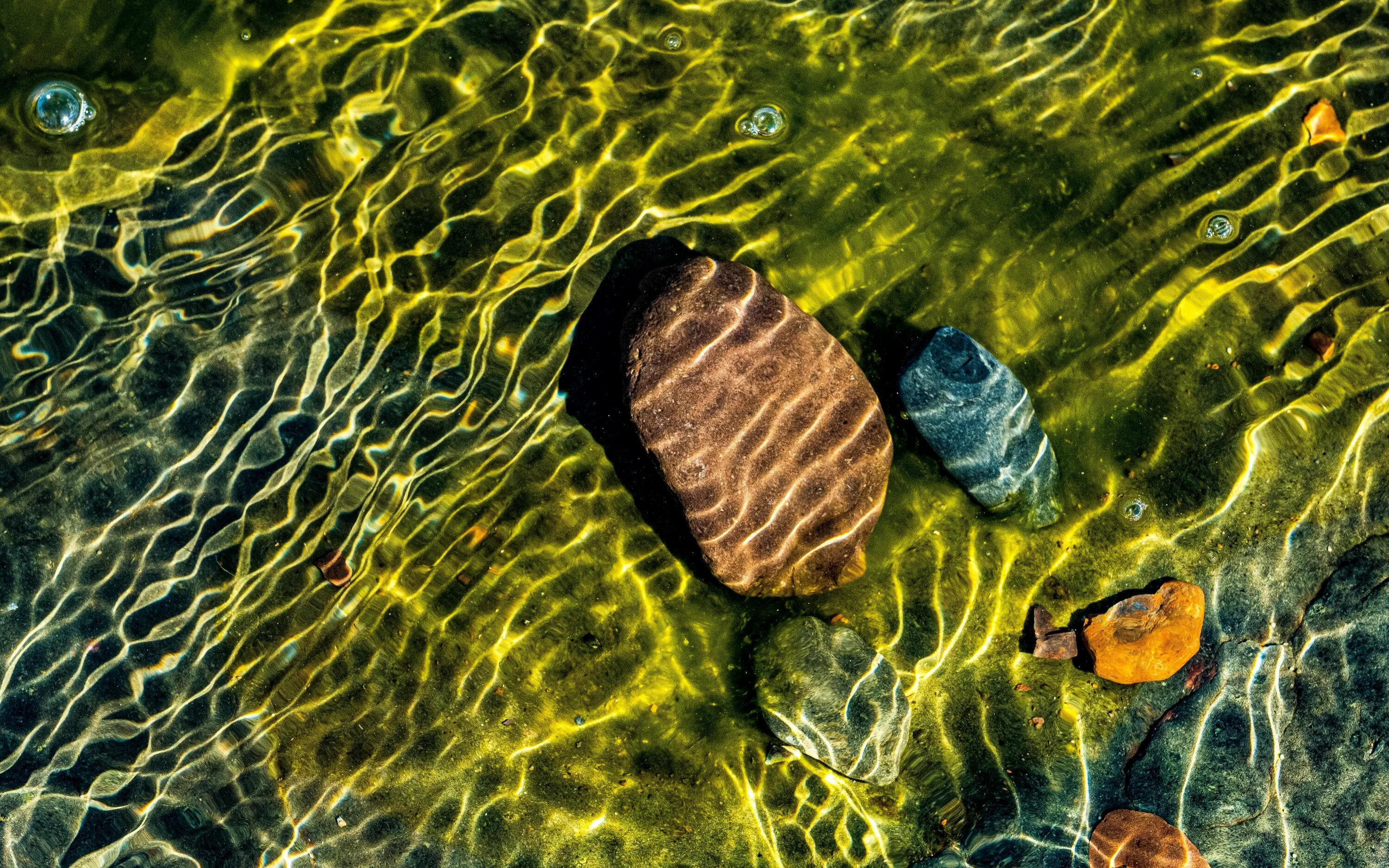 Лунник камень. Пляж боке. Блики воды на камнях. Обои камни вода. Камень туманный топаз.