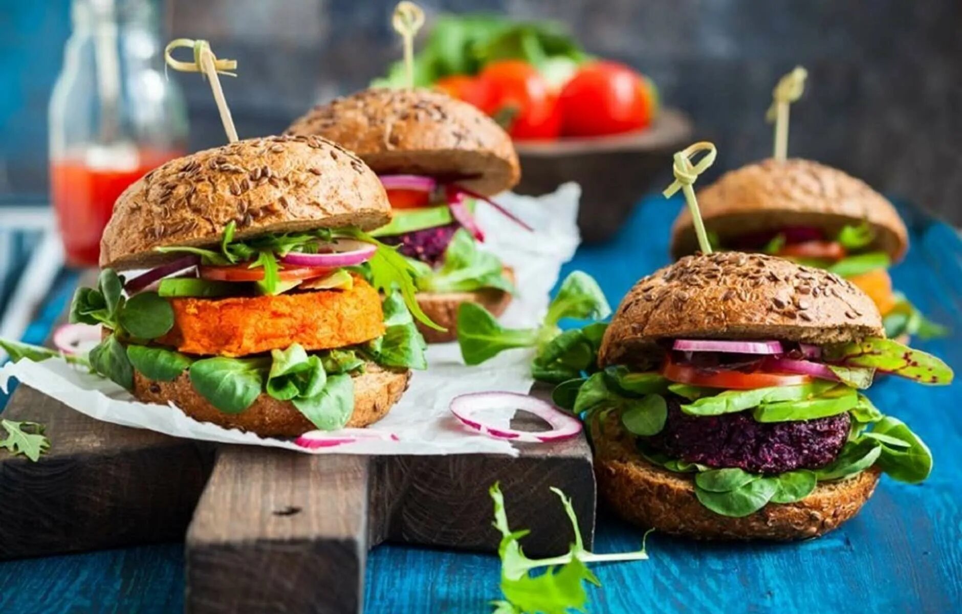 Бургеры на деревянном фоне. Food are burgers. Бургер в руках. Food are burgers. Булка для бутербродов.