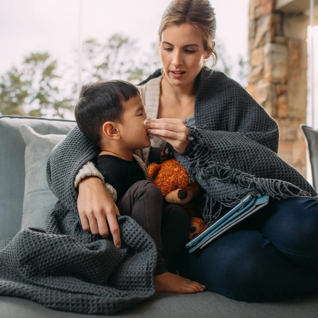 Mother and a son sick. Coughing Family Wrapped in Blankets foto.