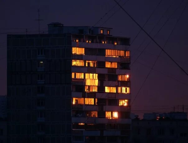 В окнах отражается солнце. Окна многоэтажки закат. Отражение заката в окнах многоэтажек. Закат отражается в окнах. Многоэтажный дом на закате.