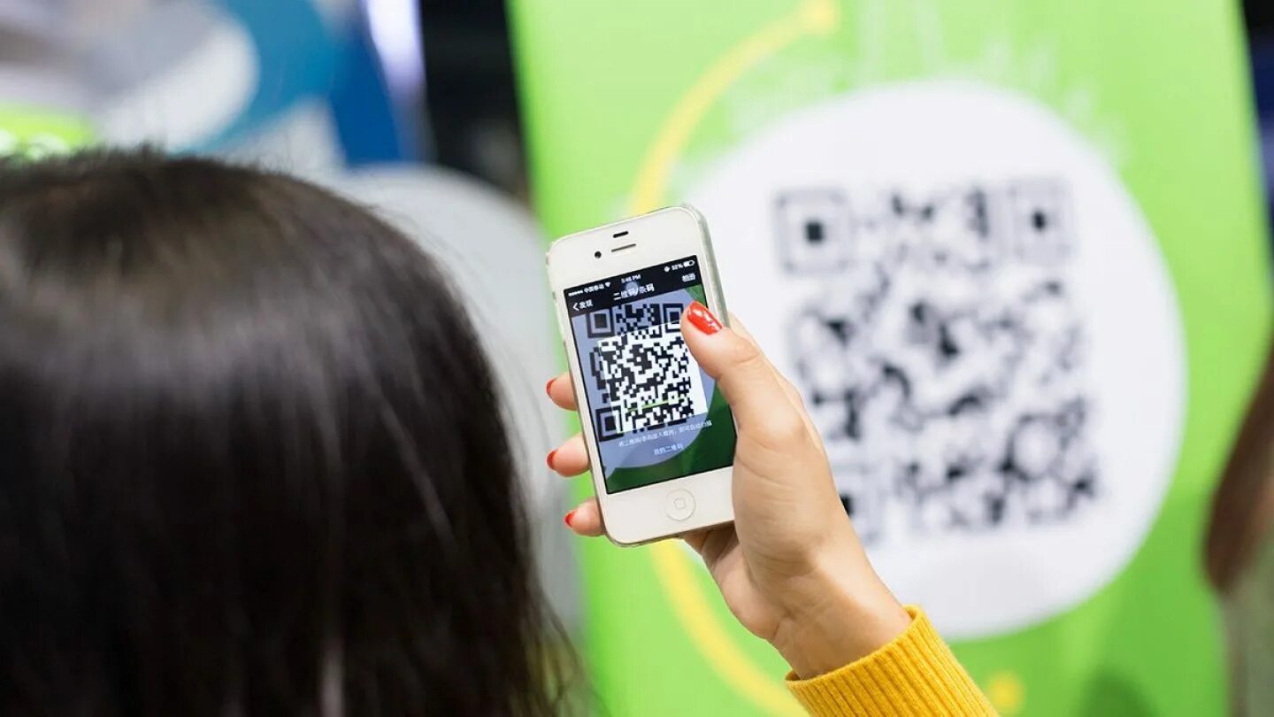 Считывание qr кода телефоном. Человек сканирует QR код. QR код на телефоне. Рука с телефоном и QR кодом. Смартфон с QR кодом на экране.