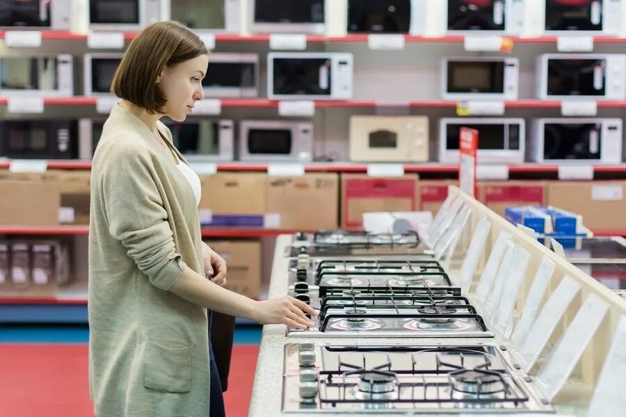 Товары в магазине техники. Выбор бытовой техники. Люди в магазине бытовой техники. Выбор бытовой техники в магазине. Покупатель в магазине техники.