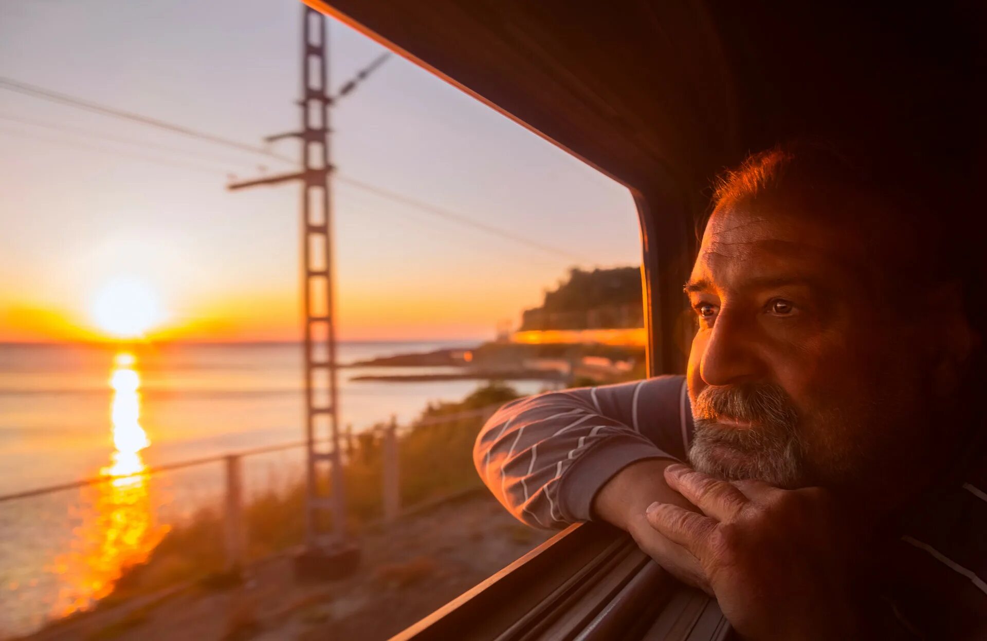 Я посмотрел на часы и понял поезд. Мужчина в поезде. Мужчина в поезде у окна. Человек в окне поезда. Поезд на закате.