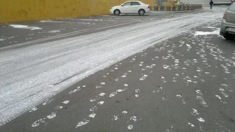 На асфальте снег ложится