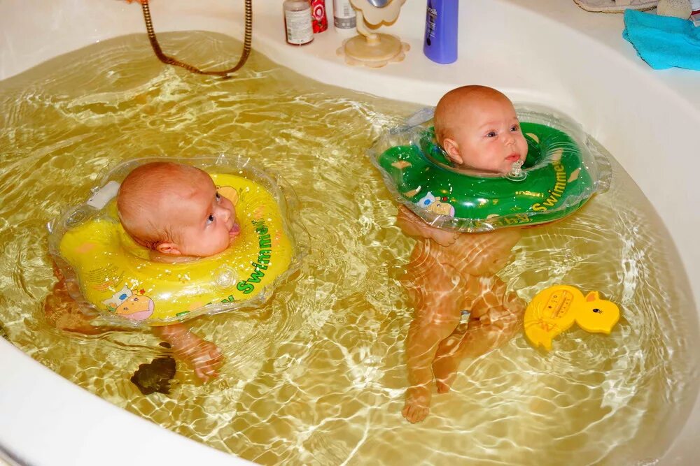 Круг для малышей для купания в ванной. Купание грудничка. Купание ребенка с кругом на шее. Ванна для грудных детей.