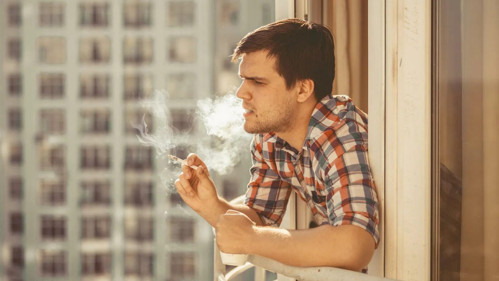 Мужчина курит на балконе. Курит у окна. Мужчина курит на балко. Курение на балконе. Курит на балконе что делать