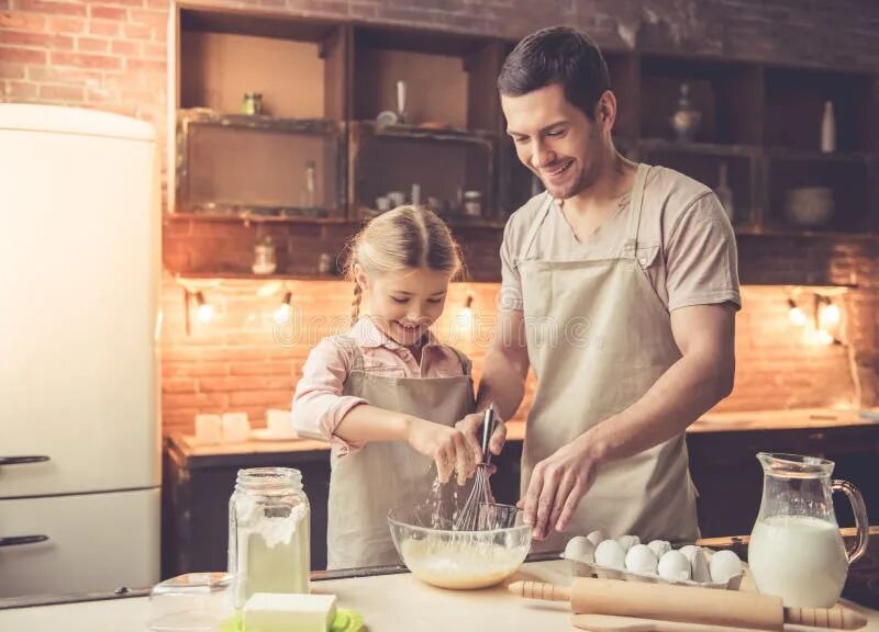 Dad a cook. Красивый отец на кухне. Папа и дочь готовят вместе. Завтрак отца и дочери. Отец готовит завтрак для дочери.