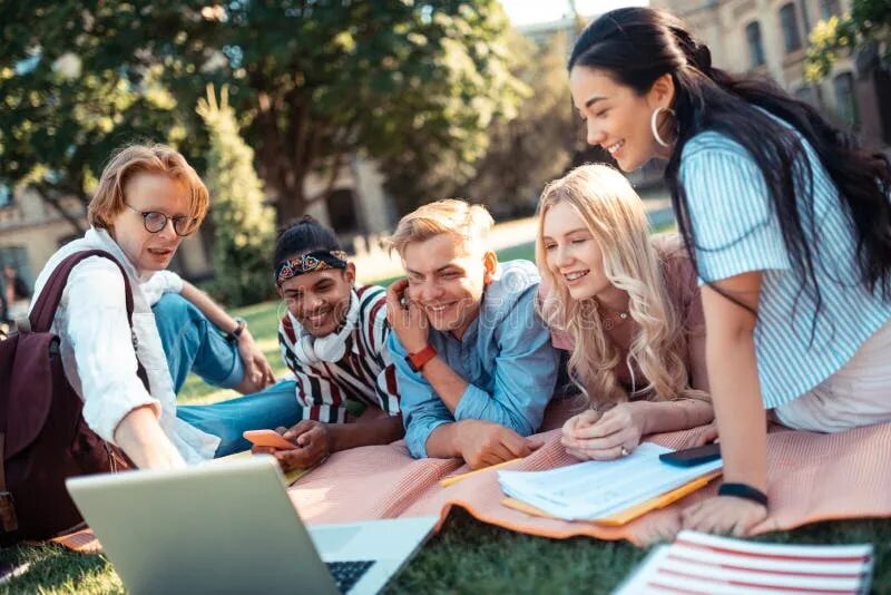 The students are watching. Cheerful students. Friends are watching a movie.