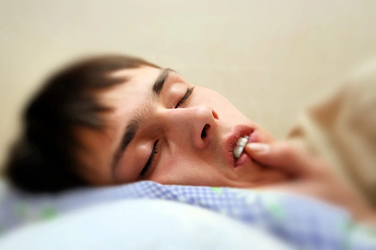 Скрипение зубами во сне. Скрежет зубами во сне у ребенка. Человек ночью скрипит зубами.