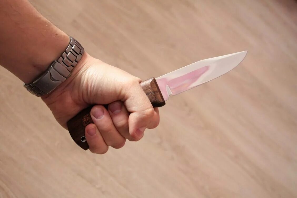 Колет ножом. Мужчинская рука с ножом.