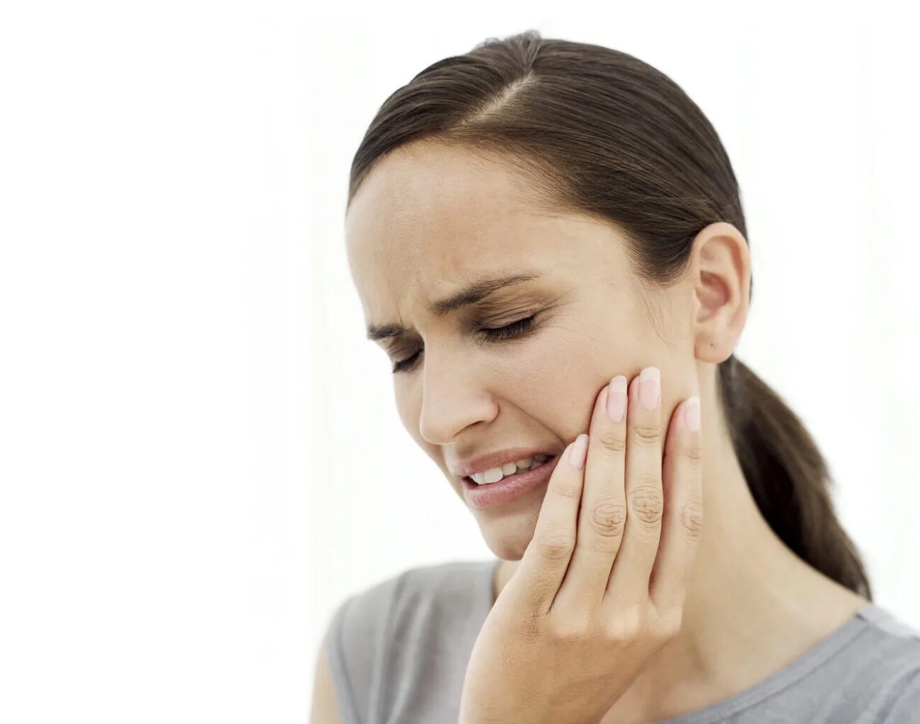 Боль в челюсти. У девушки болит зуб. Зубная боль при жевании. A toothache фото.