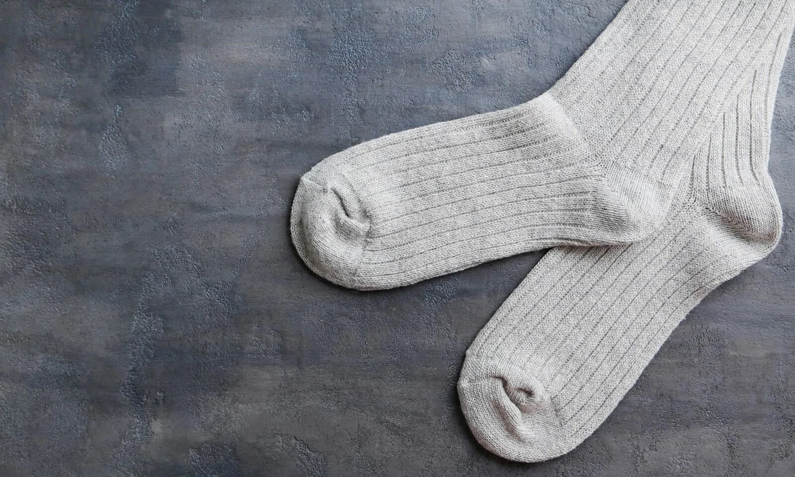 Белые носки на кровати. Носки валяются на полу. Носки мужские обычные. Носок лежит. Разбросанные носки.