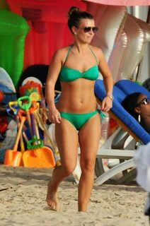 Coleen Rooney shows off her abs in an emerald bikini. 
