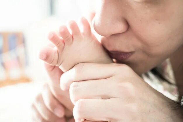 Поцелуй ножки младенца. Мама целует ножку малыша. Мама целует пяточки. Ребенок целует ноги маме.