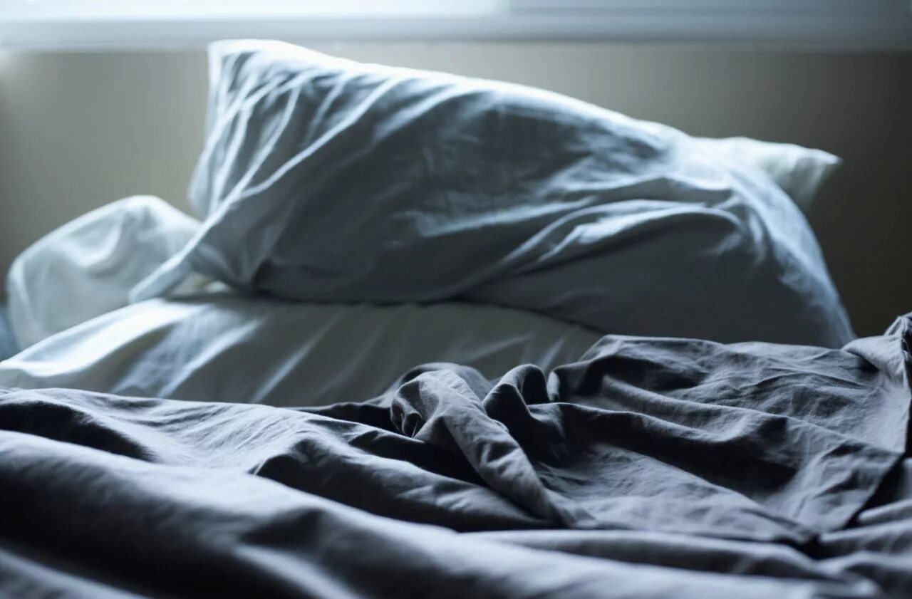 на 9 простыней. застеленная кровать. на 9 простыней. смятое покрывало на кровати.