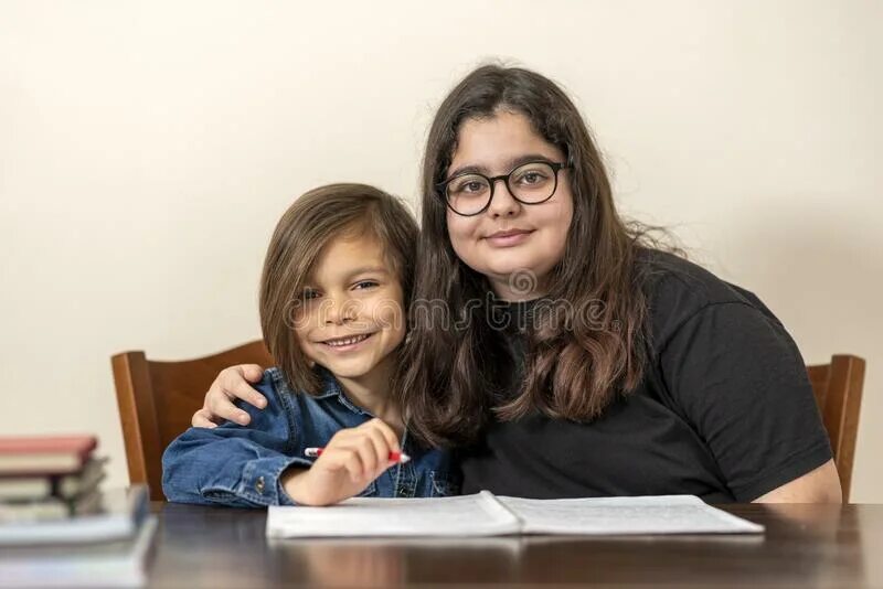 Старшая сестра учит младшую. Учит младшего брата. Сестра с братом учат уроки. Старший брат учит младшего. Брат читает книгу.