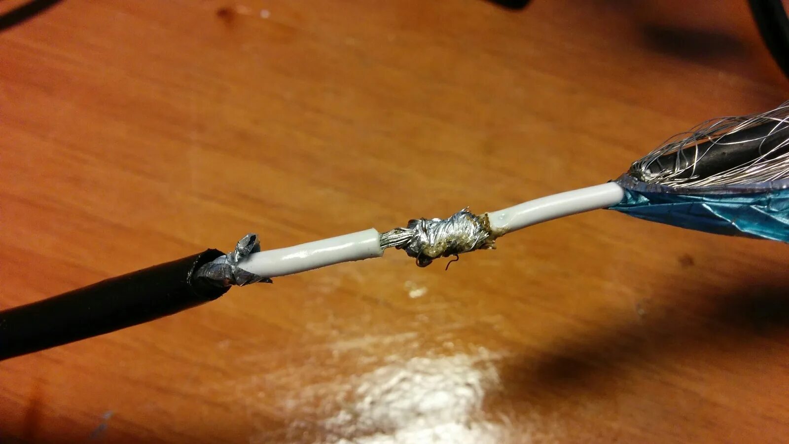 Как соединить телевизионный кабель между собой. Соединить антенный кабель пайкой. Починить провод зарядки ноутбука. Скрутка антенного кабеля. Припой антенны провода.