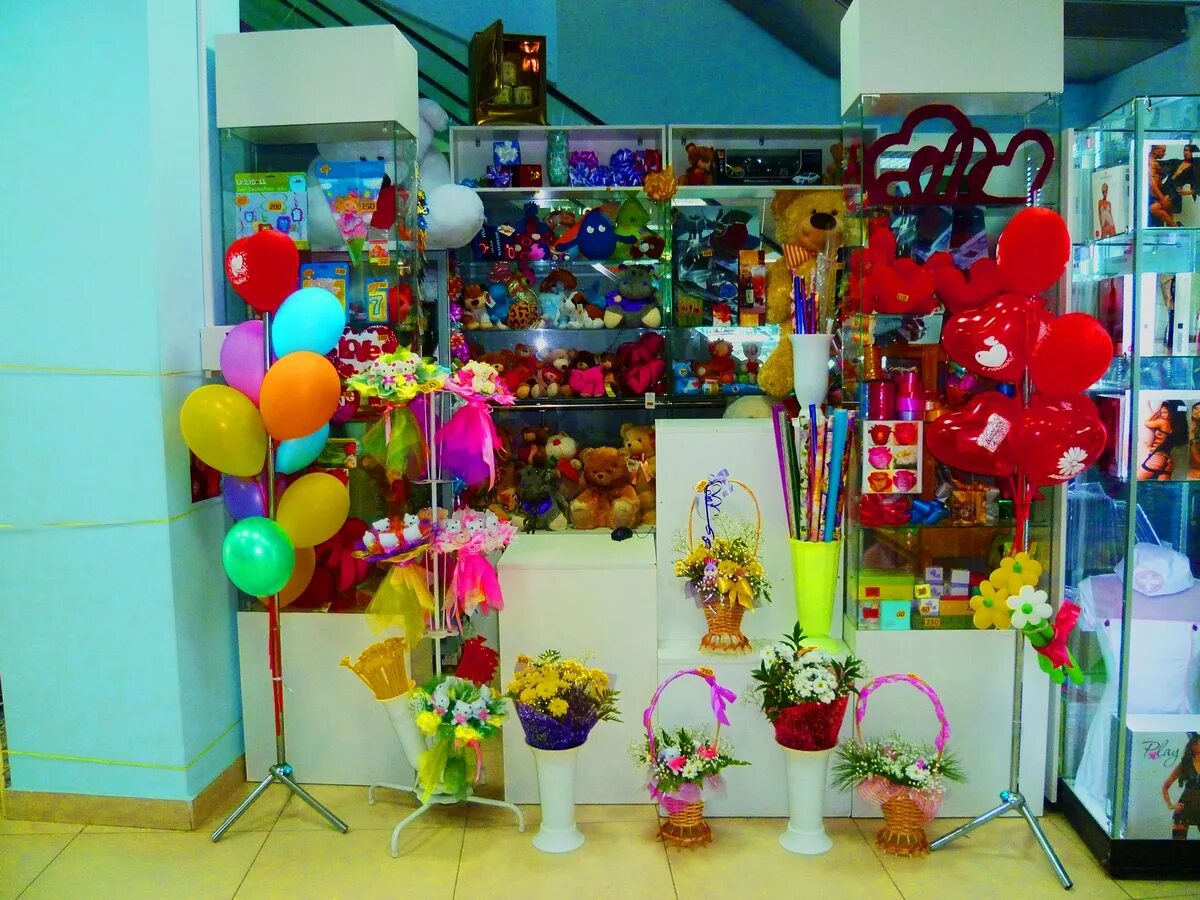 Товары для праздника. Магазин подарков и сувениров. Цветы шары подарки. Магазин цветов и подарков.