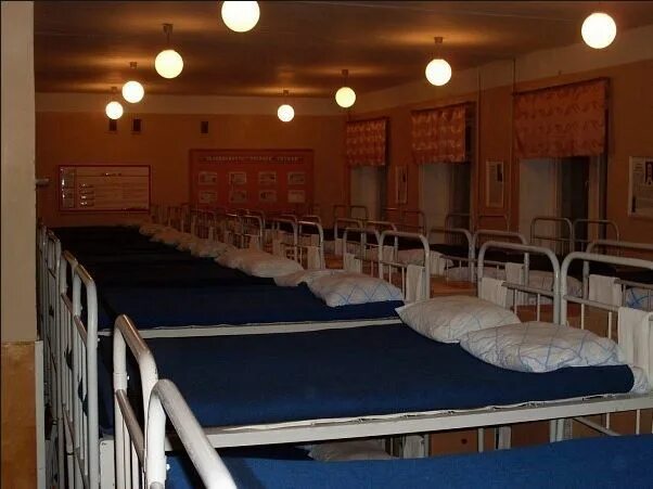 Спящий солдат в казарме. Отбой в лагере. Ночная казарма. Кровати в казарме. Спальное помещение в казарме.