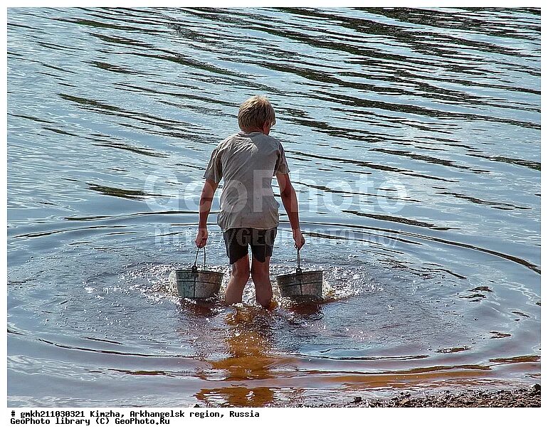 Воду из реки ведром. Вычерпывать воду. Мужик с ведром воды. Черпает воду из реки. Мальчик с ведром воды.