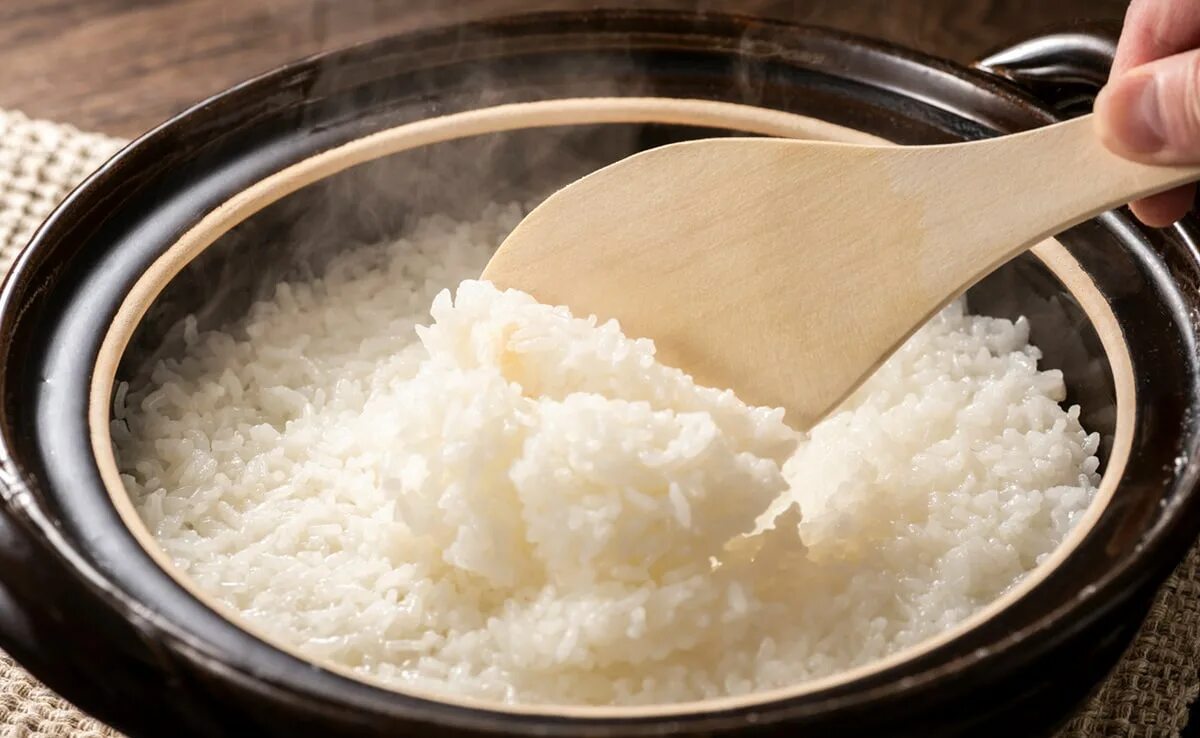 Кипящий рис. Сыпать рис в посуду. Hand arroz.