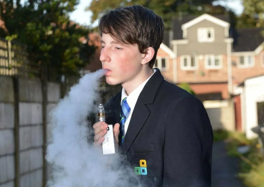 Подростк с электронный сигаретой. Школьники курят. Курящий школьник. Школьник с электронной сигаретой.