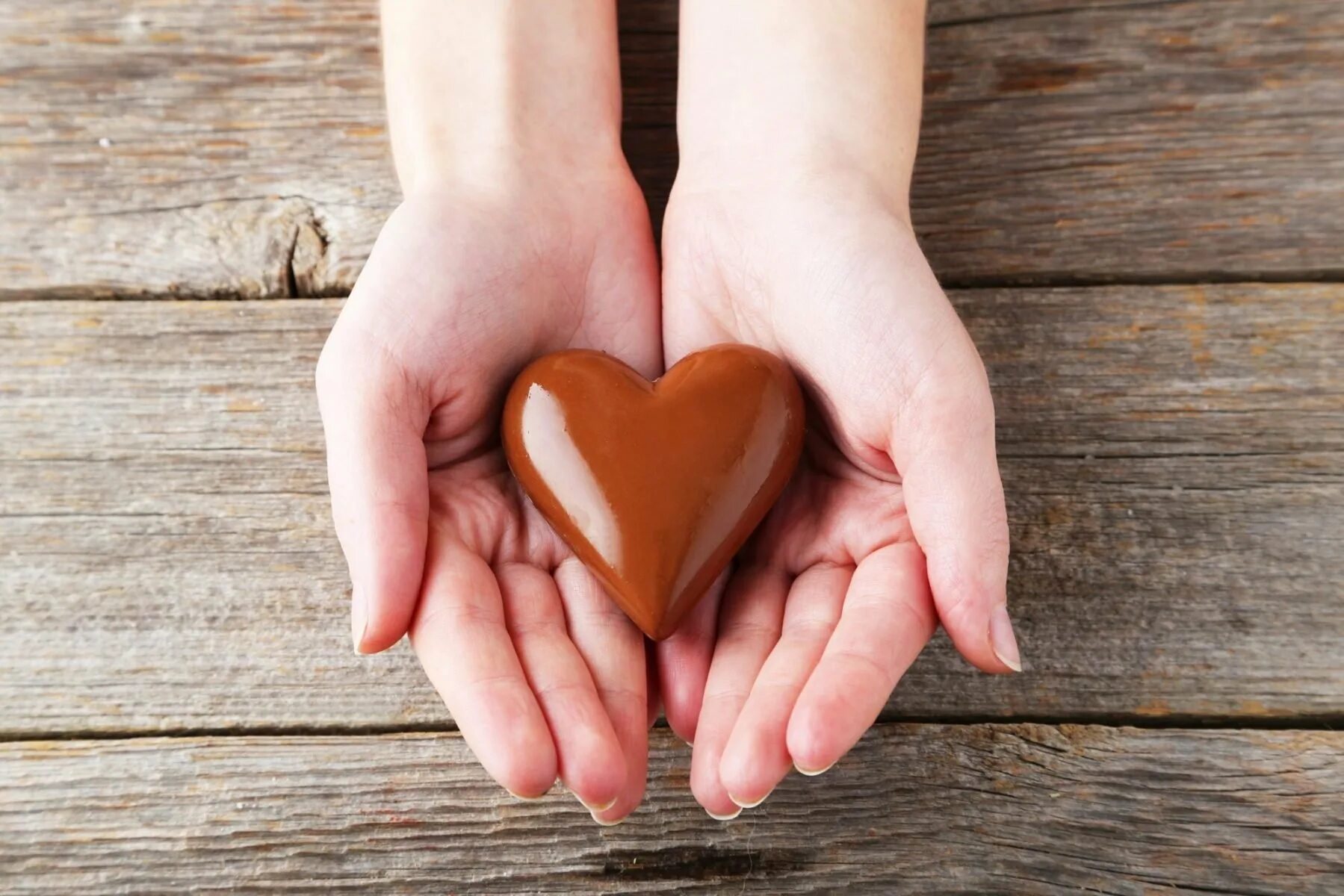 Почему шоколад тает в руках. Шоколадные сердечки. Конфета в руке. Шоколад в виде сердца в руках. Сердце в руках.