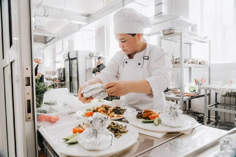 повар кухонный работник. повар центр город. повар за плитой. студенты повара. повар с тарелкой.