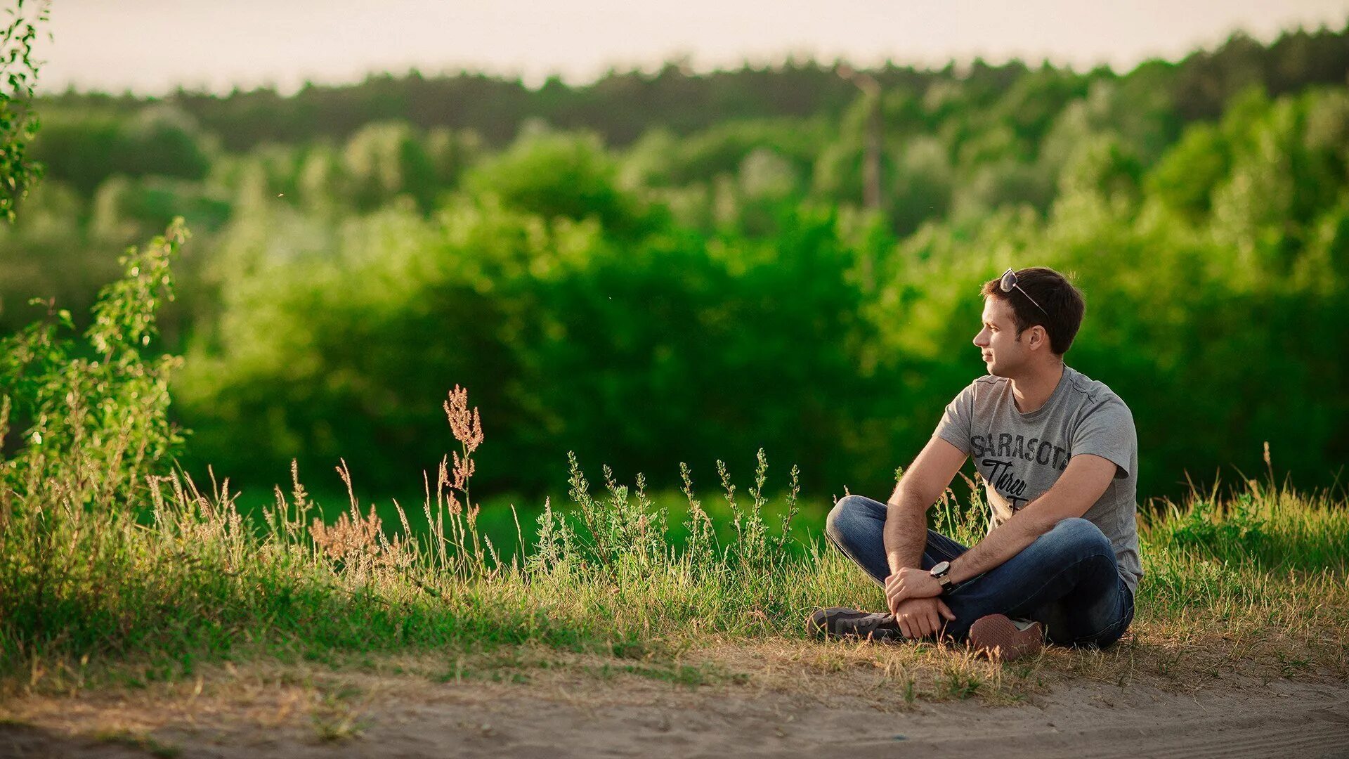 Человек смотрит в поле. Человек сидит на траве. Парни на природе. Мужчина на природе. Человек и природа.