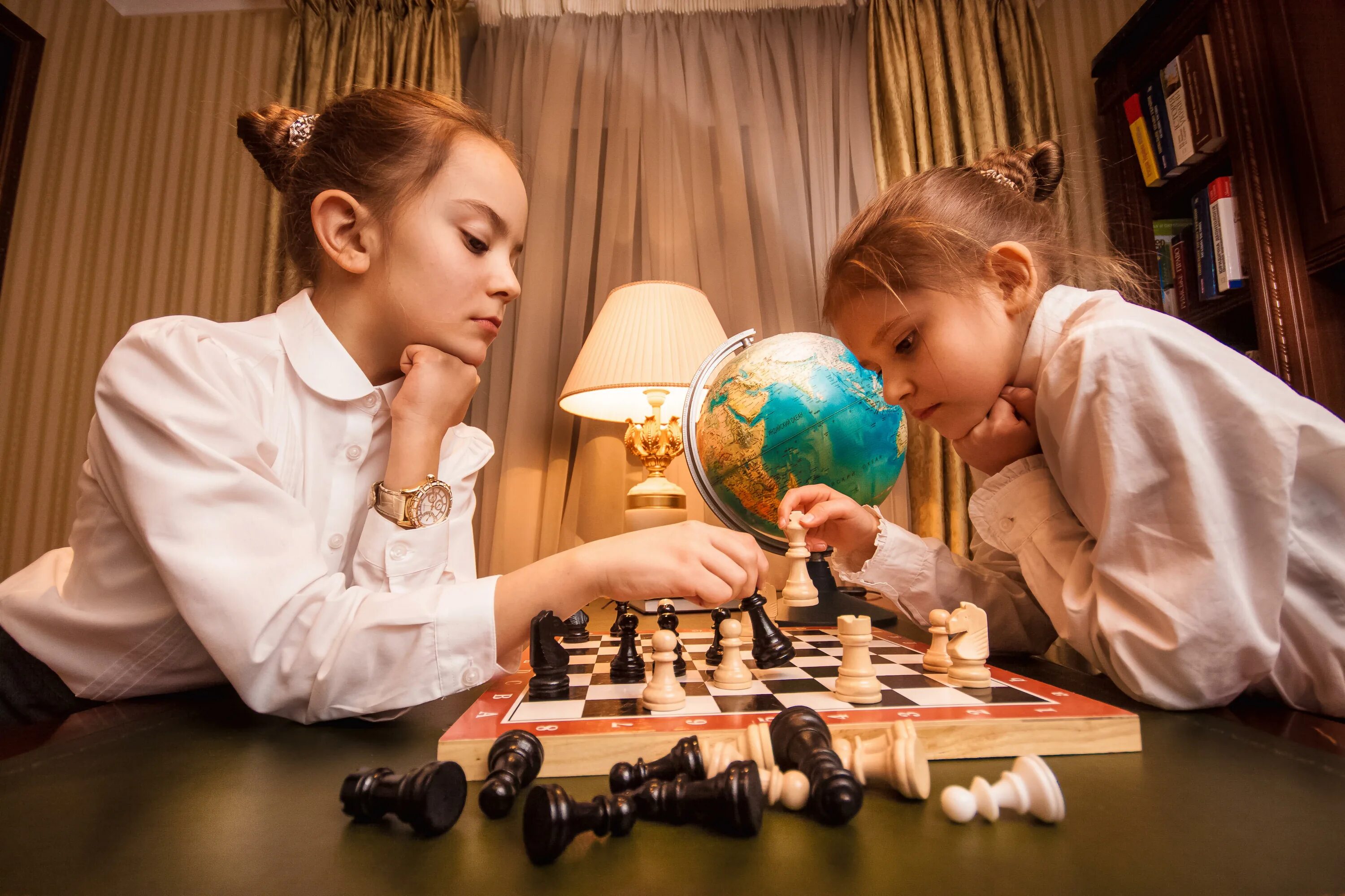 Играть двоим на доске. Дети играют в шахматы. Шахматы для детей. Девочка играет в шахматы. Две девушки играют в шахматы.