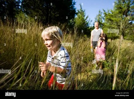 A woman and her young children hike through a grassy field near the Eightmi...
